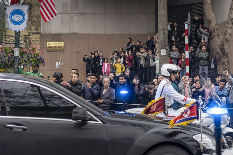 Người dân vẫy tay chào mừng khi chiếc xe Mercedes S600 Pullman Guard chờ nhà lãnh đạo Triều Tiên lăn bánh trên phố Lý Thường Kiệt và đang hướng về phía khách sạn Melia.