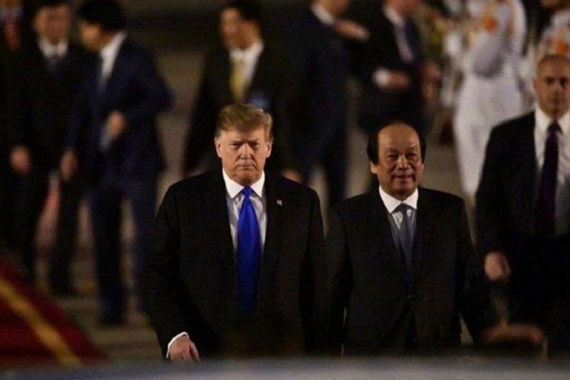 Tổng thống Donald Trump bước đi trong sân bay Nội Bài, cùng Bộ trưởng, Chủ nhiệm Văn phòng Chính phủ, Mai Tiến Dũng (Ảnh: NQL)